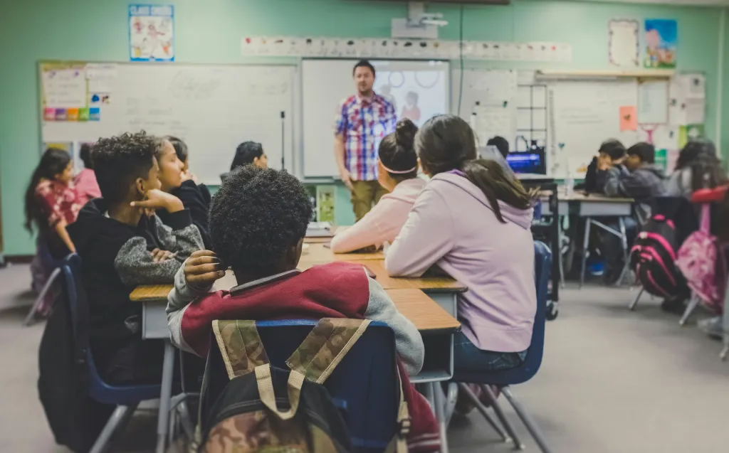 A teacher demonstrates how to use a smart board to solve a  problem