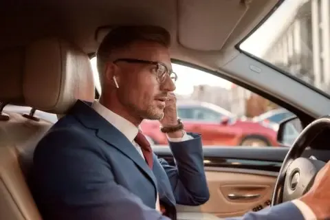 man driving with wirless earphones airpods distracted driving