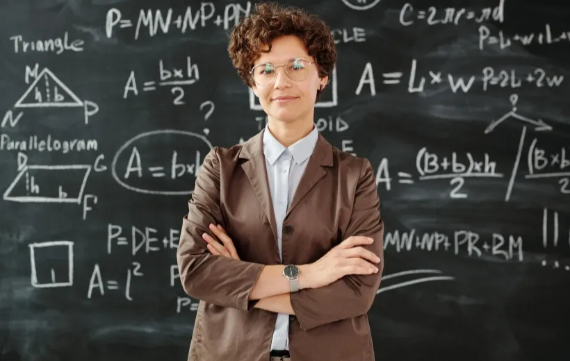 math teacher stands before a blackboard