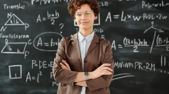 math teacher stands before a blackboard