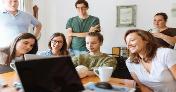 Mehrere personen versammelten sich um einen computer fuer ein remote meeting