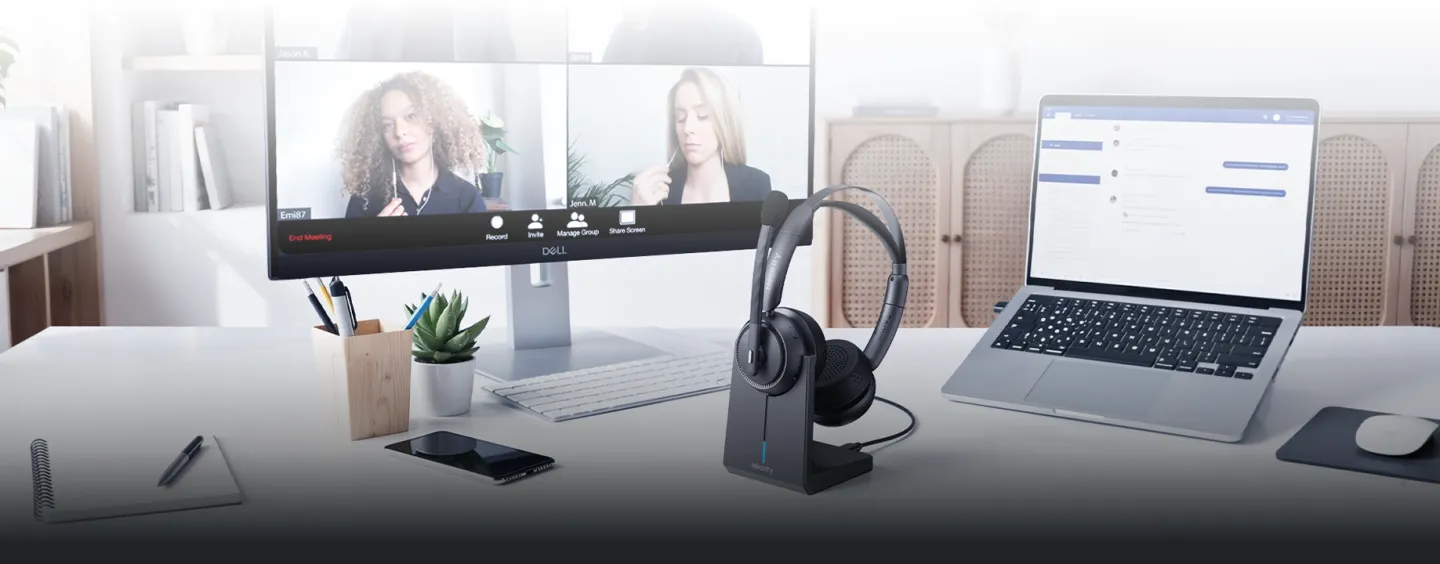Black noise cancelling headphone with mic for office on a desk charging stand during a video call.