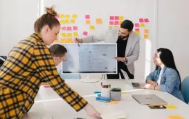 A creative team collaborating on a 30-inch touch screen monitor