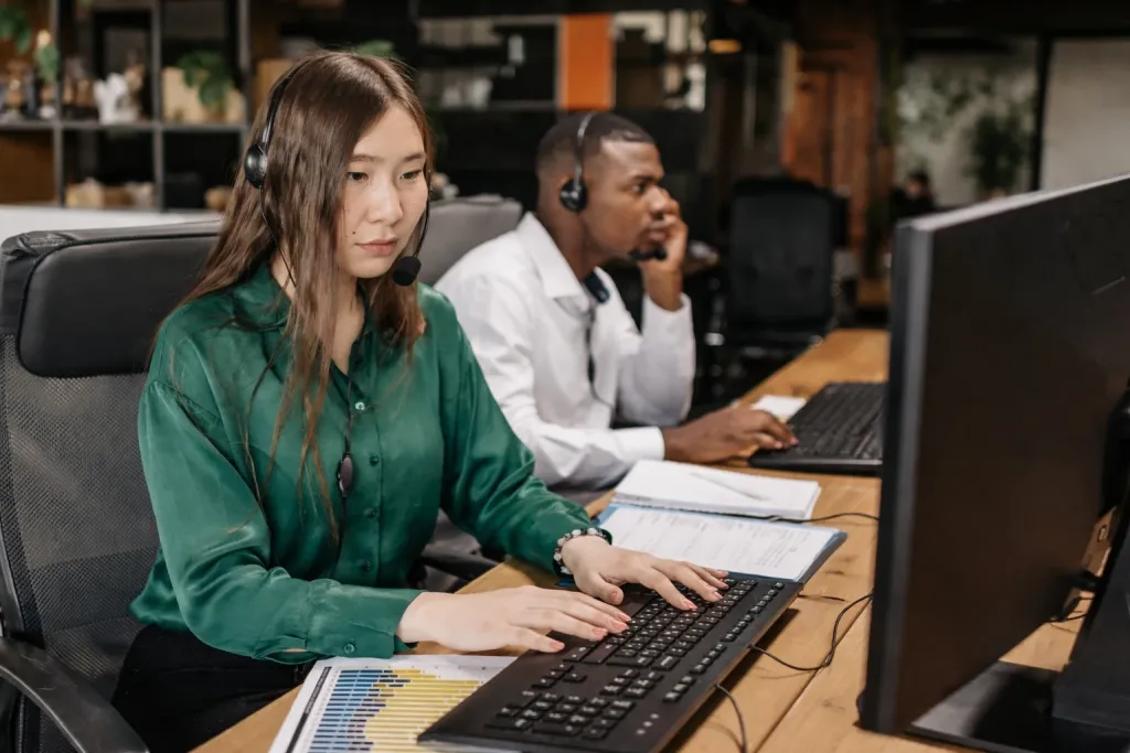 オフィスで社員が事務業務のOJT研修を受けているシーン