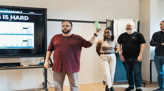 A team in a modern office connecting a laptop to an interactive smartboard for a presentation