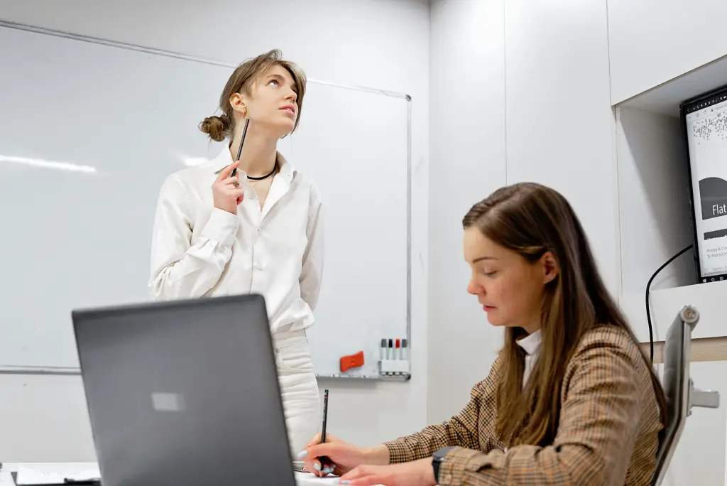 Mitarbeiterinnen diskutieren ueber die digitales whiteboard kosten