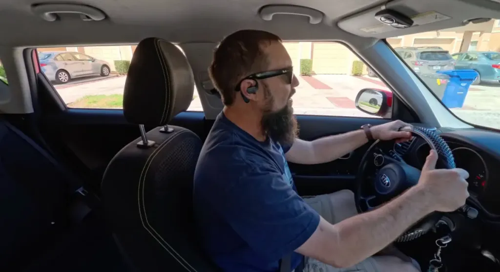 a man is driving with best earbuds for call quality