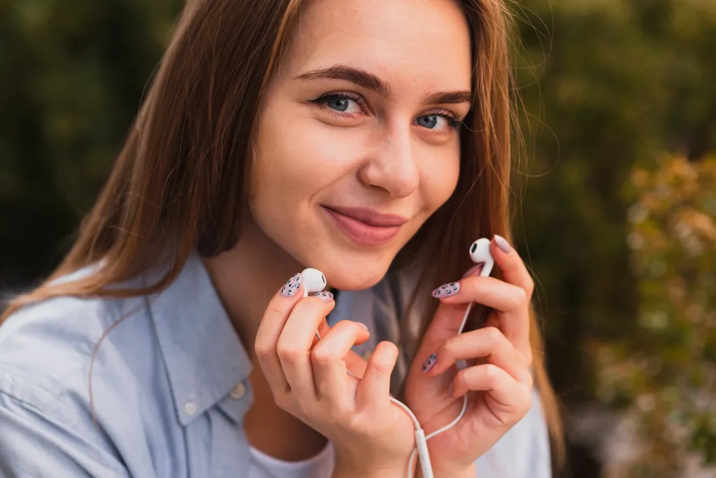 a woman is holding best earbuds for meetings