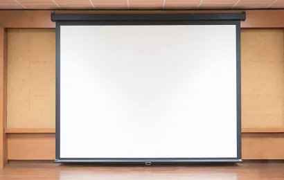 木製の背景壁にプロジェクター用ホワイトボードが掛けられている。