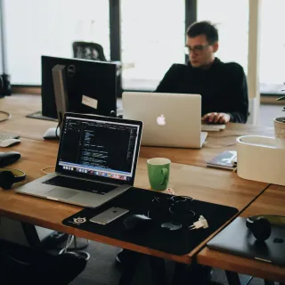 A man sit on the black best standing desk converters