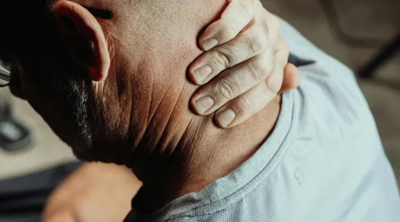 An old man feels neck hurts sitting at desk