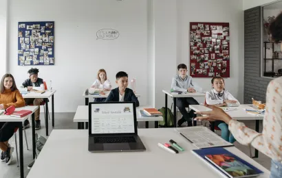 生徒たちが真剣に学校向けプロジェクターがある教室で授業を受けています。