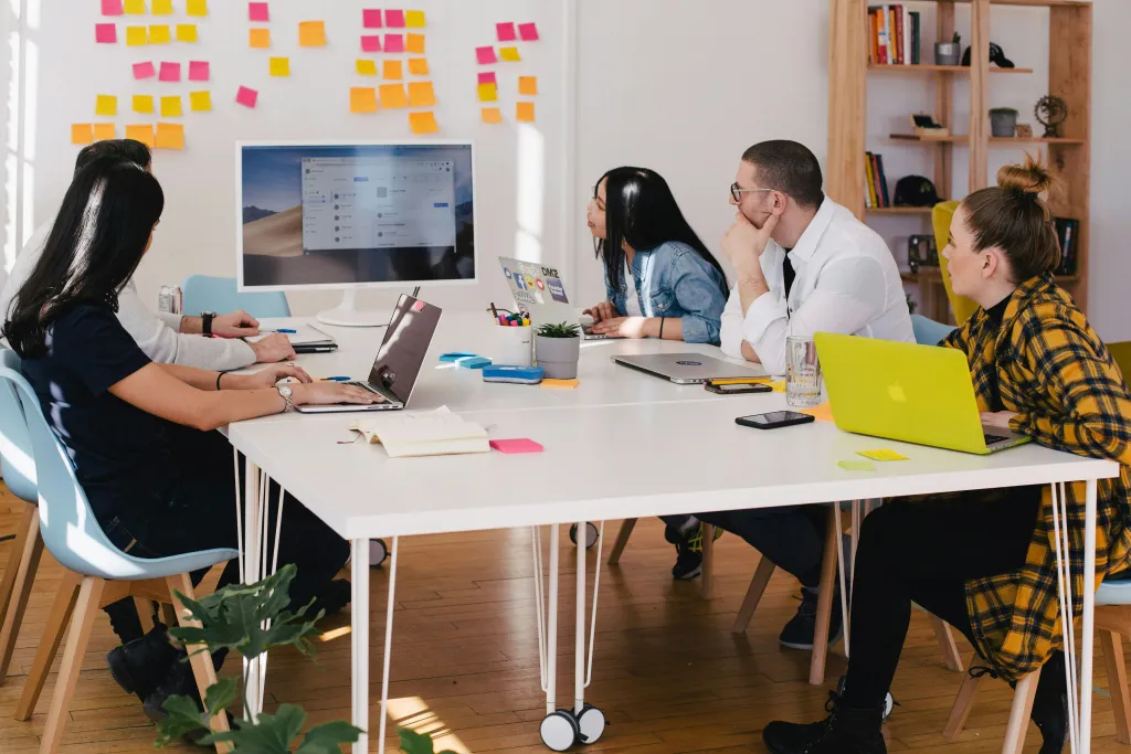 Employees collaborate with a digital message board