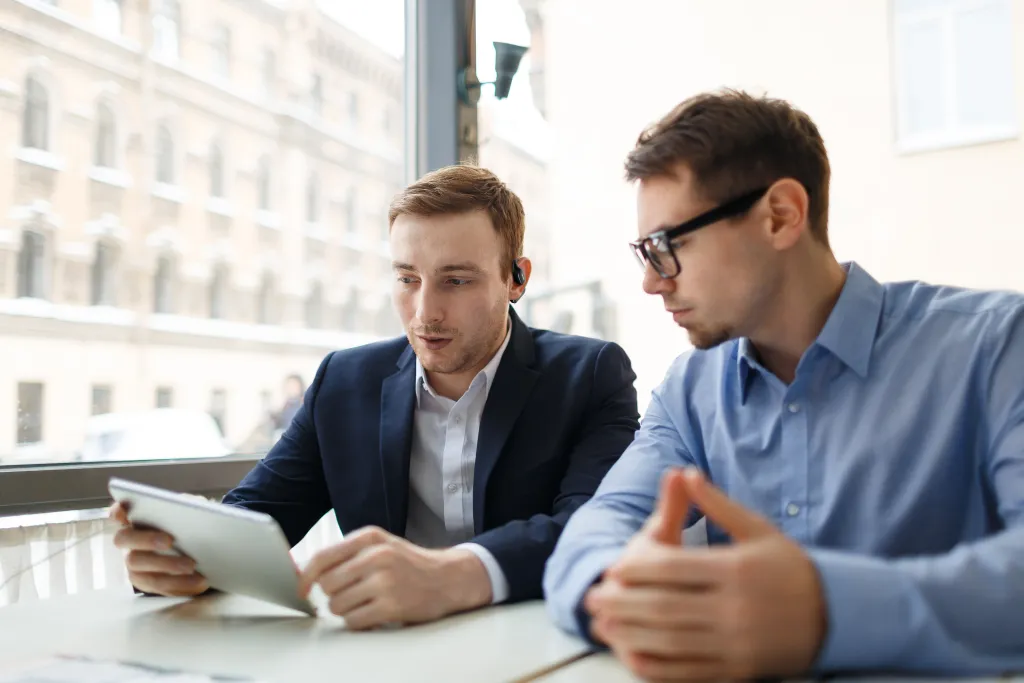 Two men wearing the best earbuds when talking.