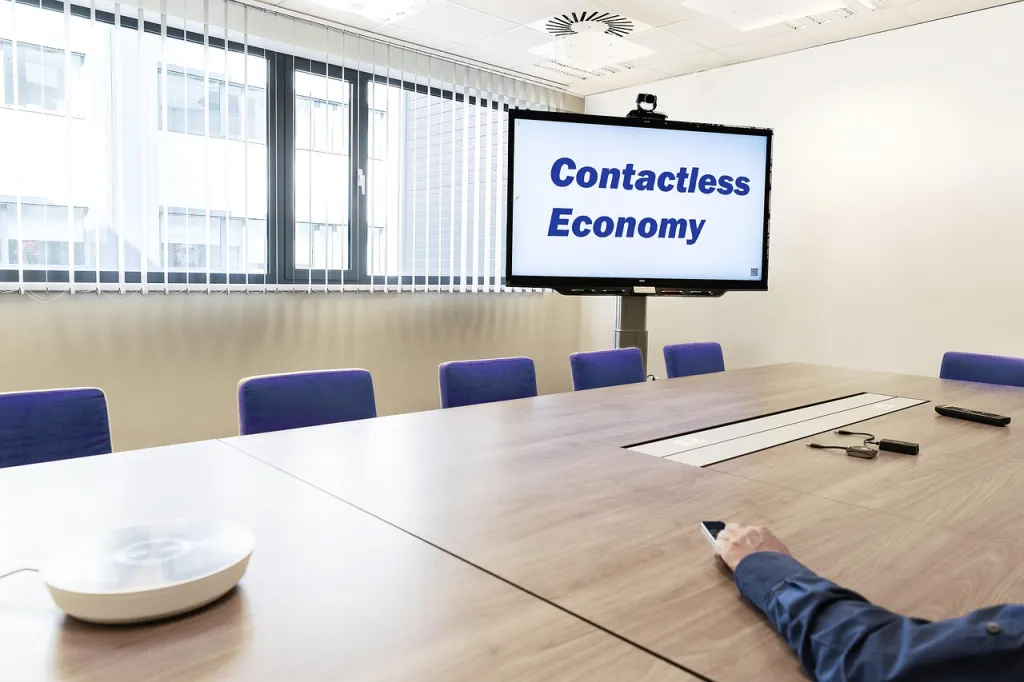 an office meeting is made more tiny with a digital message board