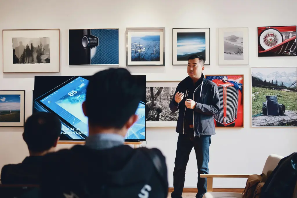 A male instructor engaging his class on a large smart interactive whiteboard, showcasing its clear advantage for teaching over a small 30 inch touch monitor