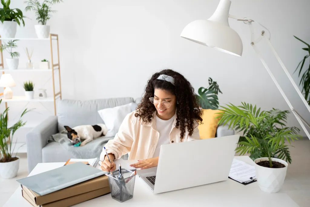 Woman working remotely on a laptop in a cozy cafe with a cup of coffee.
