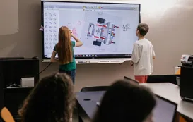Zwei Schueler vor einem whiteboard fuer schulen im Klassenzimmer