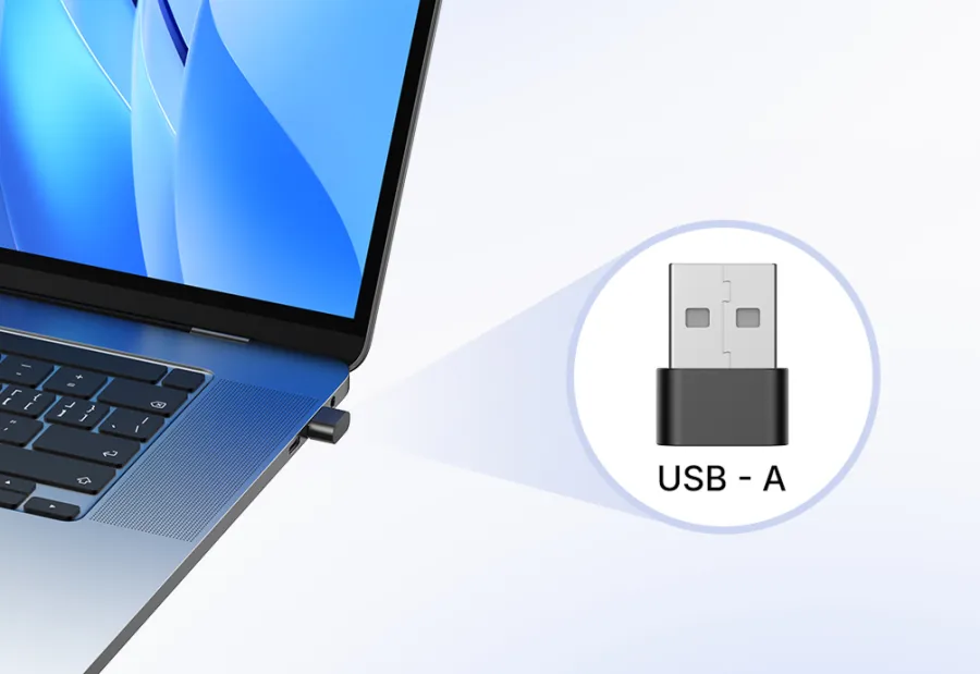 USB-A dongle connection for wireless headset with mic for work plugged into a silver laptop.
