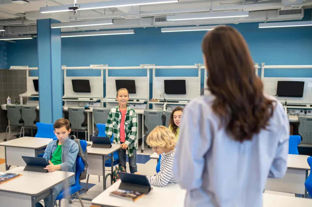 woman-looking-girl-answering-standing-near-desk.jpg