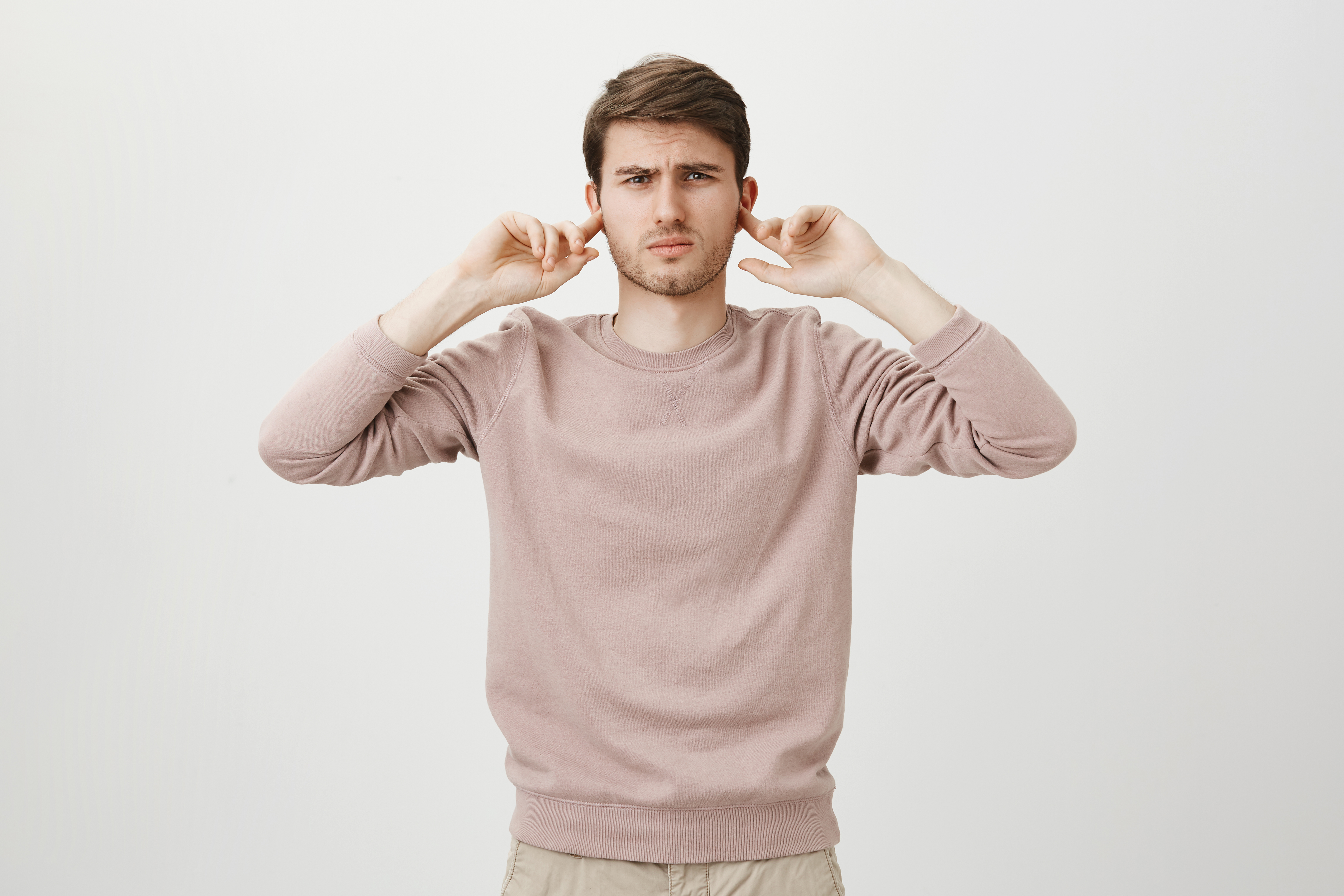 displeased-man-shut-ears-from-loud-noise.jpg