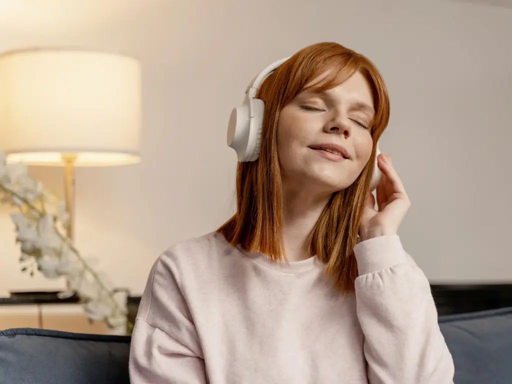 Close-up portrait of a woman wearing white headsets for immersive home listening
