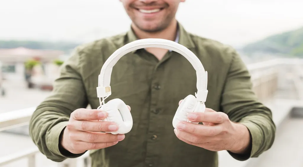 Man showing the ear cushions of over-ear headphones