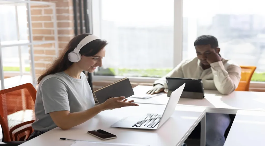 Office workers using headsets in a collaborative workspace