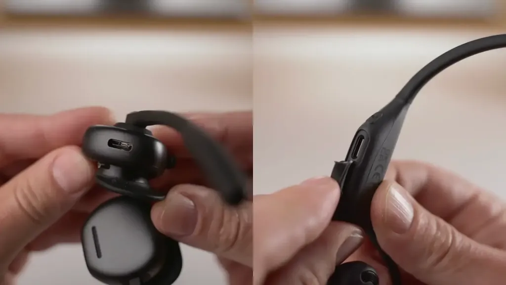 Shokz Open Meet and Nuroum OpenEar Pro 2 open-ear headsets showing their direct headset charging ports, requiring a cable connection for recharging