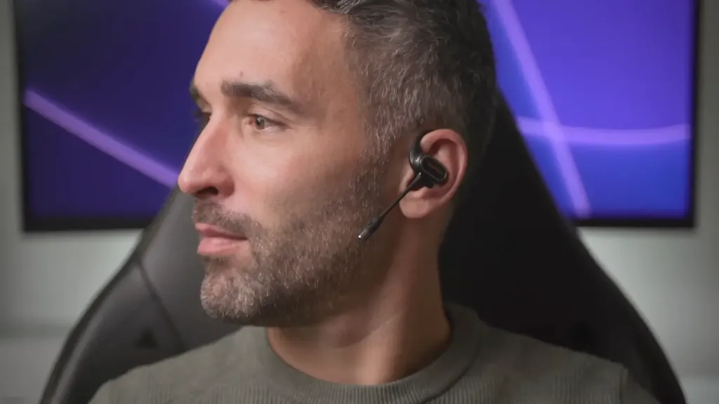 Andy wearing OpenRock Link 20 open-ear earbuds with detachable magnetic boom mic, highlighting the lightweight, portable design suitable for office and outdoor activities.