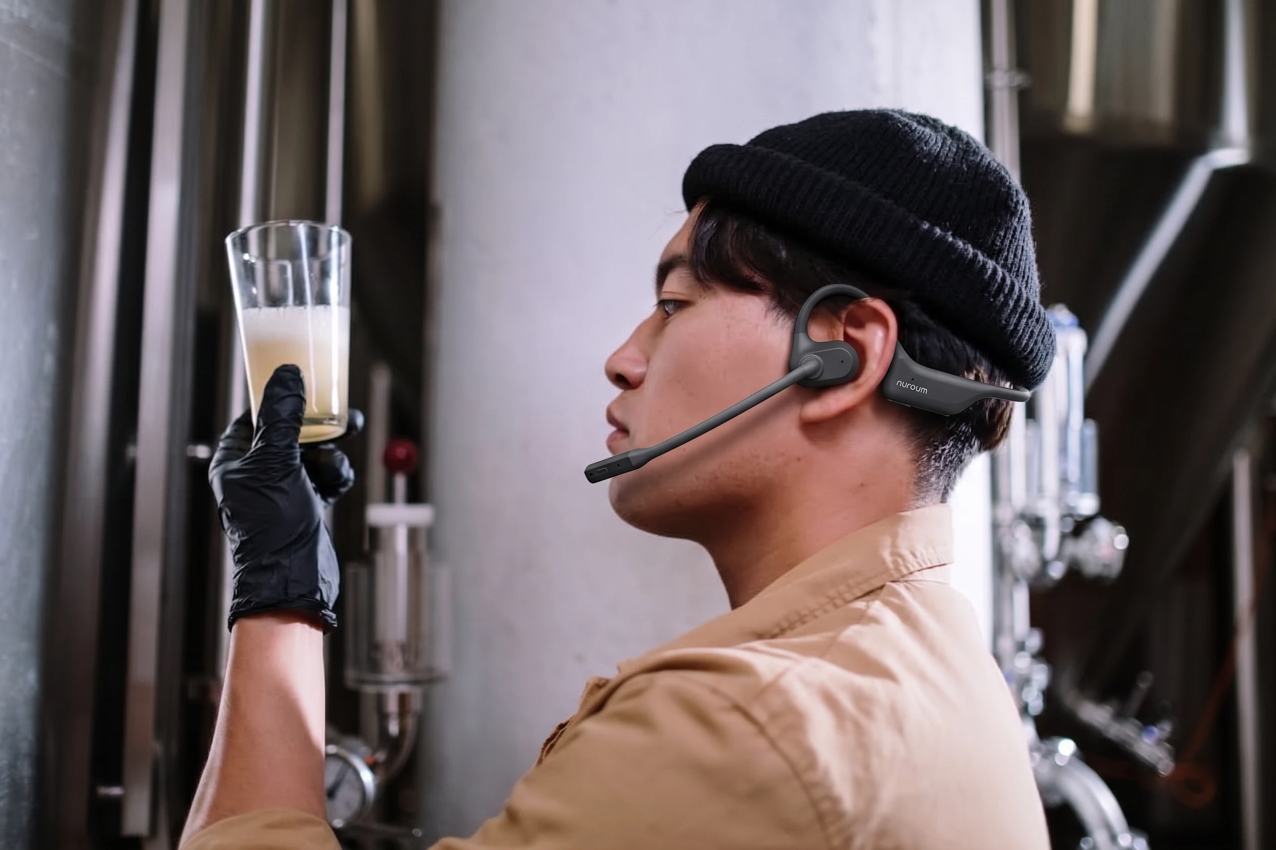 Line supervisor looking at tablet on manufacturing floor while wearing open-ear headset
