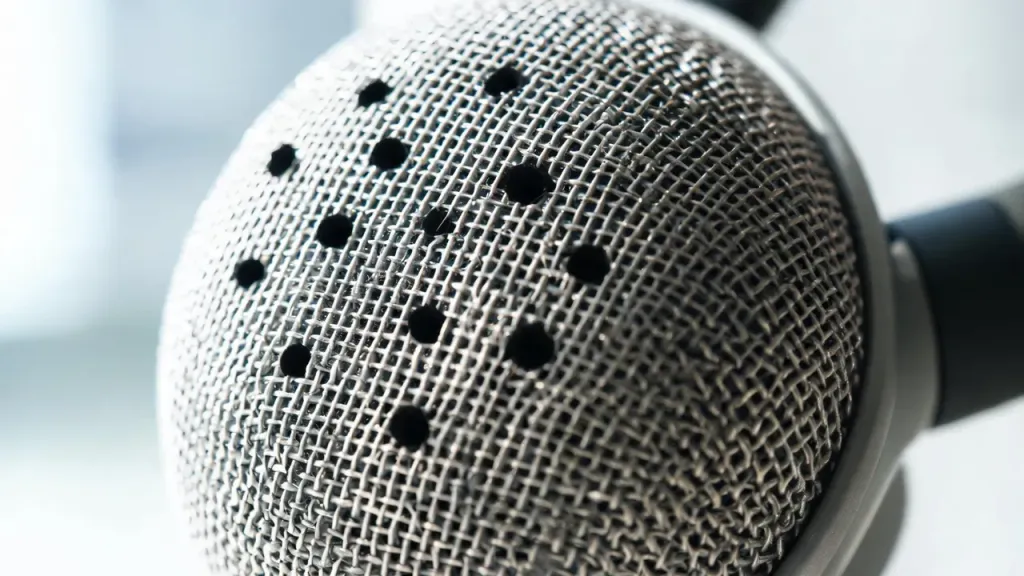 Extreme close-up of a microphone array, showing the multiple small pinholes on a headset boom microphone