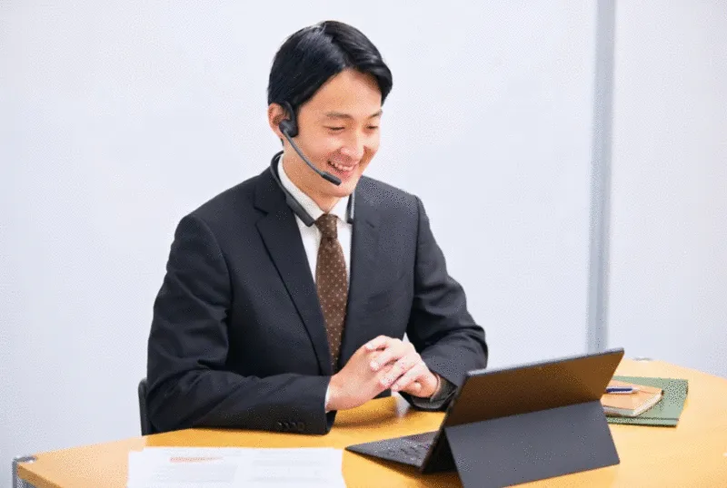 ビジネスパーソンがweb会議用ヘッドセットを装着してオンライン会議に参加している様子