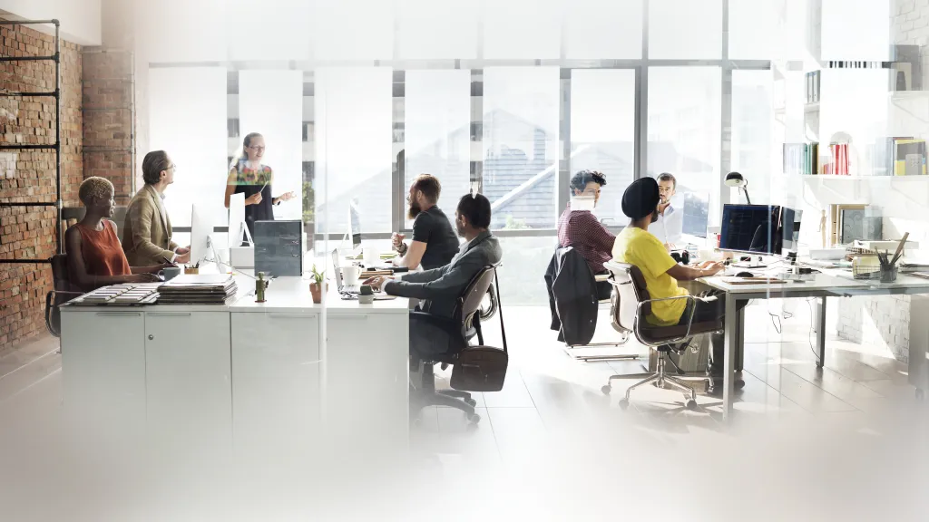 A busy, collaborative open-plan office workspace, illustrating the noisy tech environment where engineers require the best noise cancelling headphones for coding.
