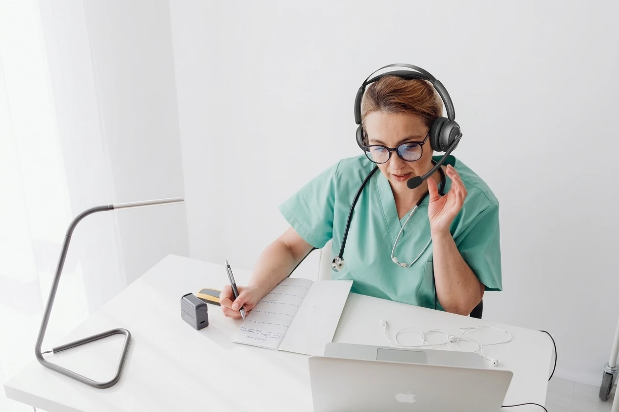 Doctor in white coat conducting telehealth session with noise cancelling headset