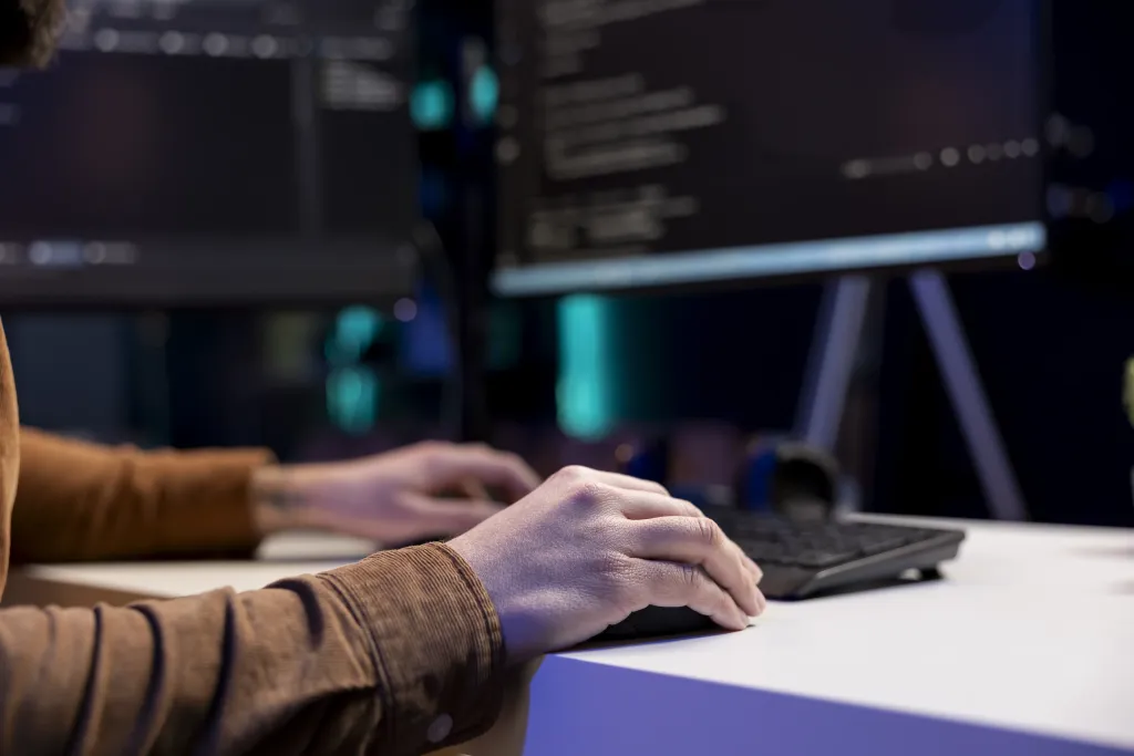 A developer typing code on a loud mechanical keyboard, illustrating why software engineers need the best noise cancelling headphones for coding.
