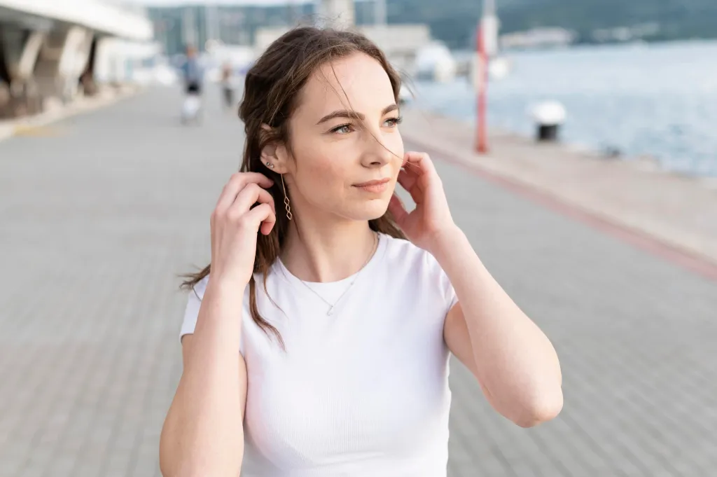 this smiling girl wants to know the answer of bone conduction vs open ear headphones