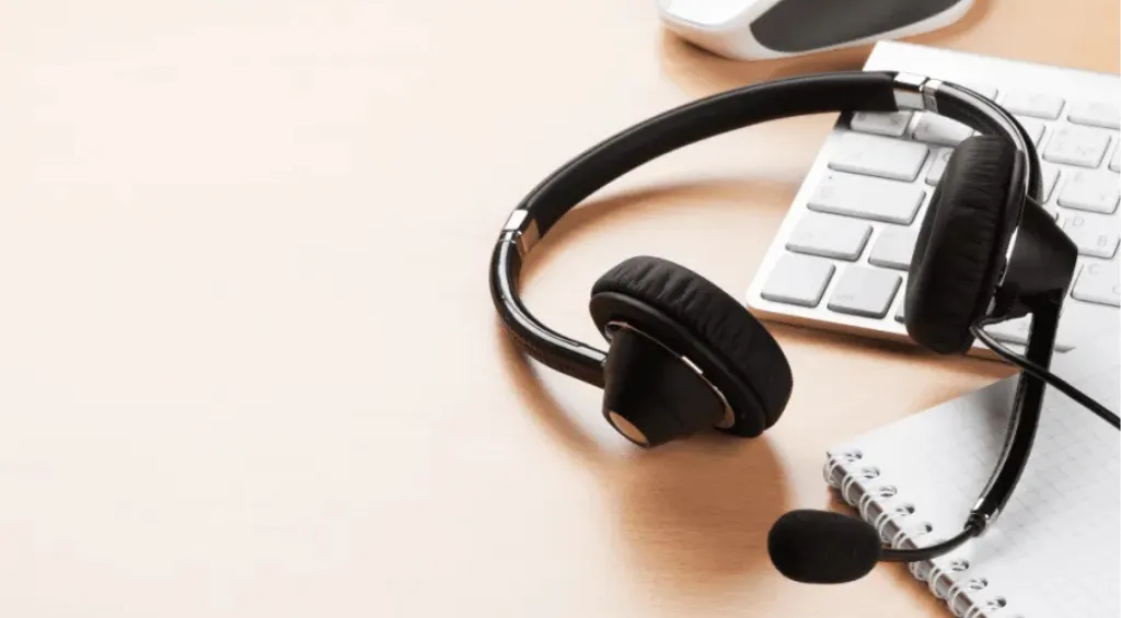 Black wireless headset with boom microphone on a desk, illustrating the difference between microphone noise cancellation for clearer calls and ANC for reducing background noise.