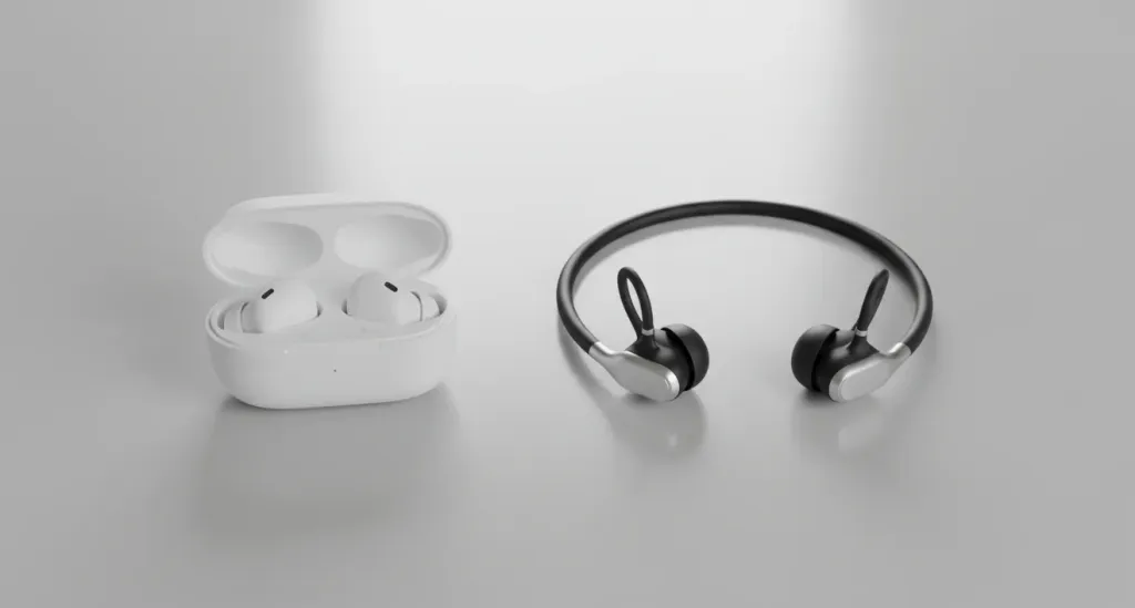 Zwei verschiedene Headset-Typen nebeneinander: In-Ear Ohrhörer in einem Ladecase und ein Open-Ear Knochenleitungs-Headset auf einer hellen Oberfläche