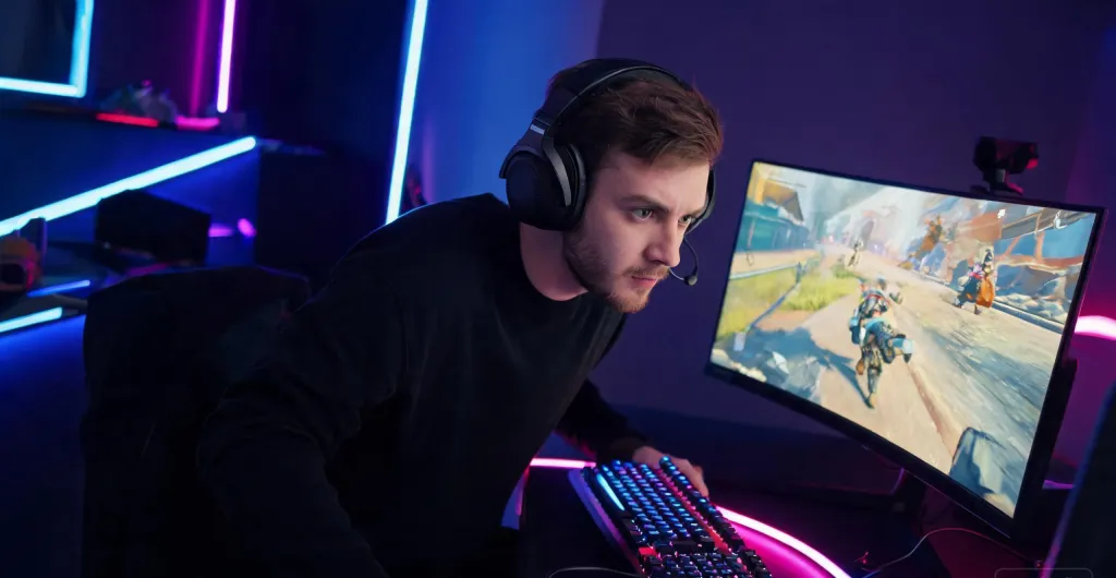 Gamer wearing a wireless headset, focused on a fast-paced competitive game with RGB ambient lighting