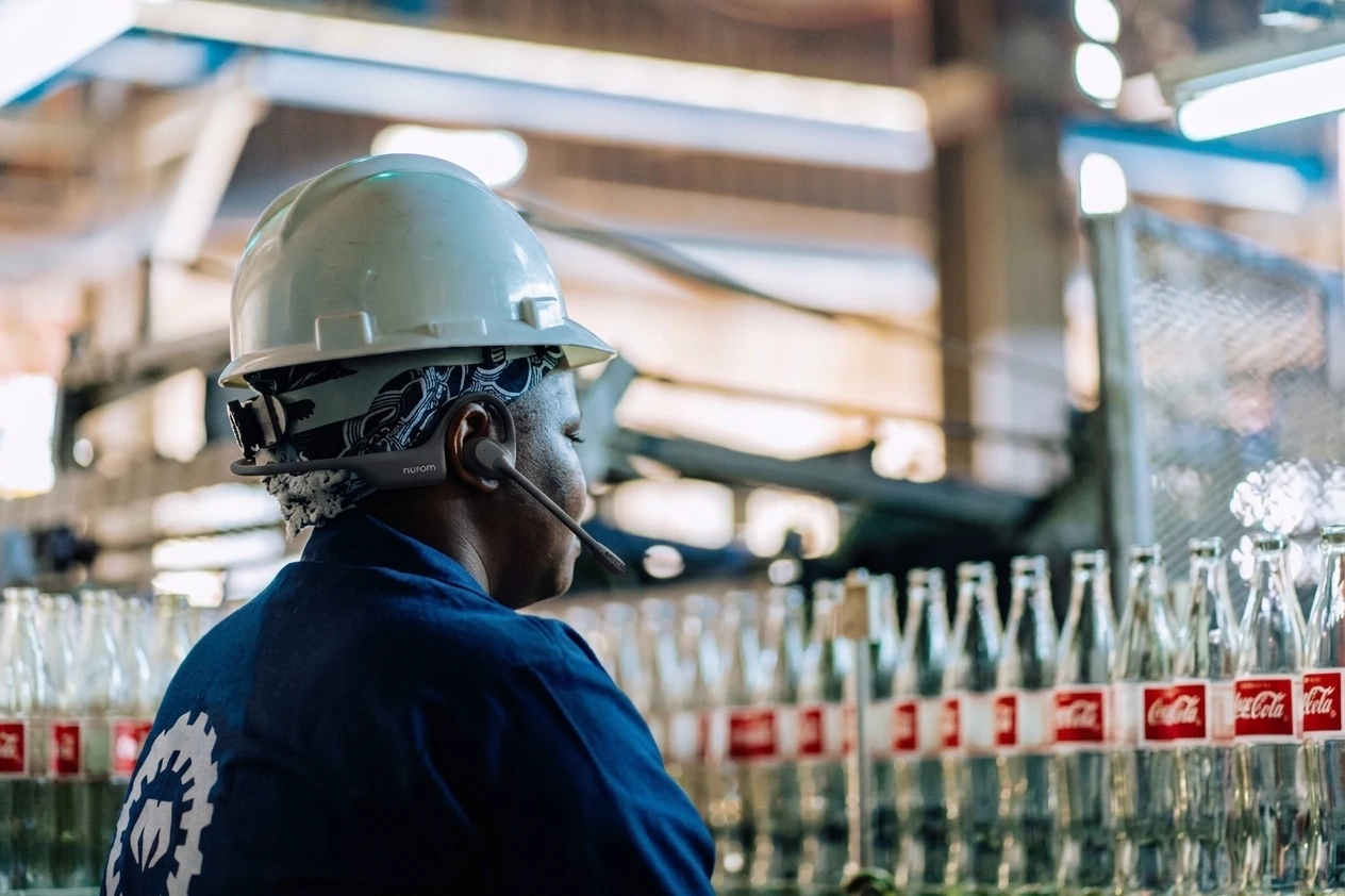 Plant operations director wearing lightweight communication headset on factory floor