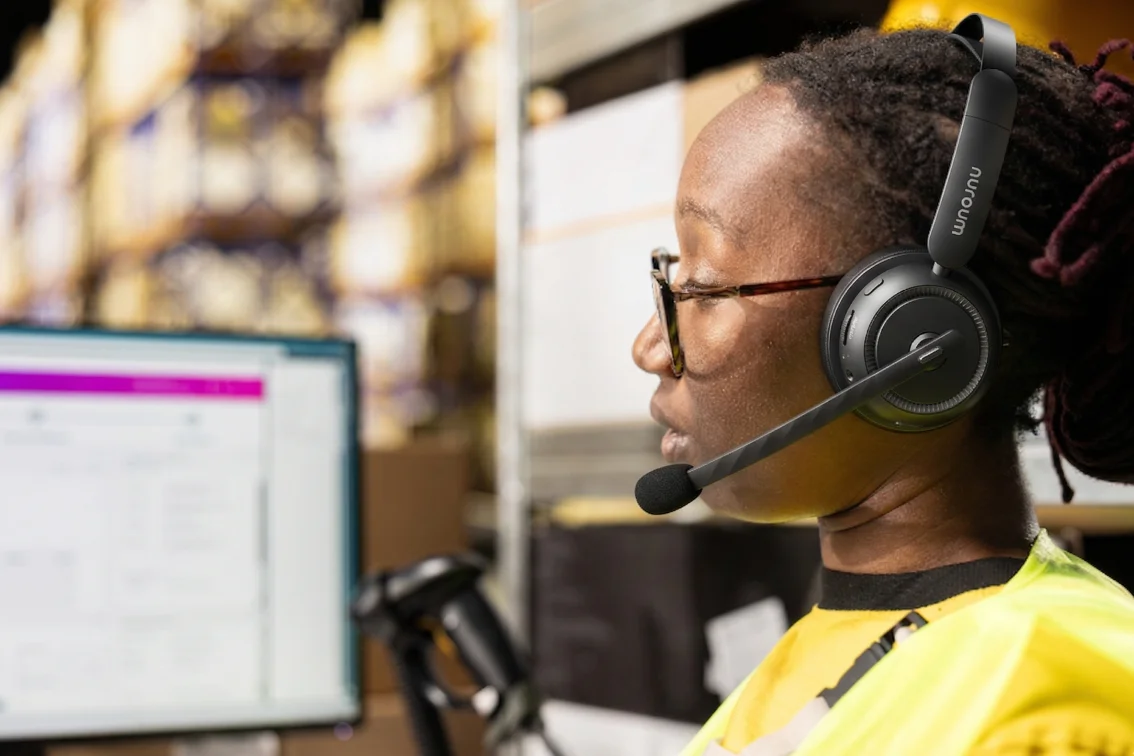 Logistics dispatcher using dual ear wireless headset at desk