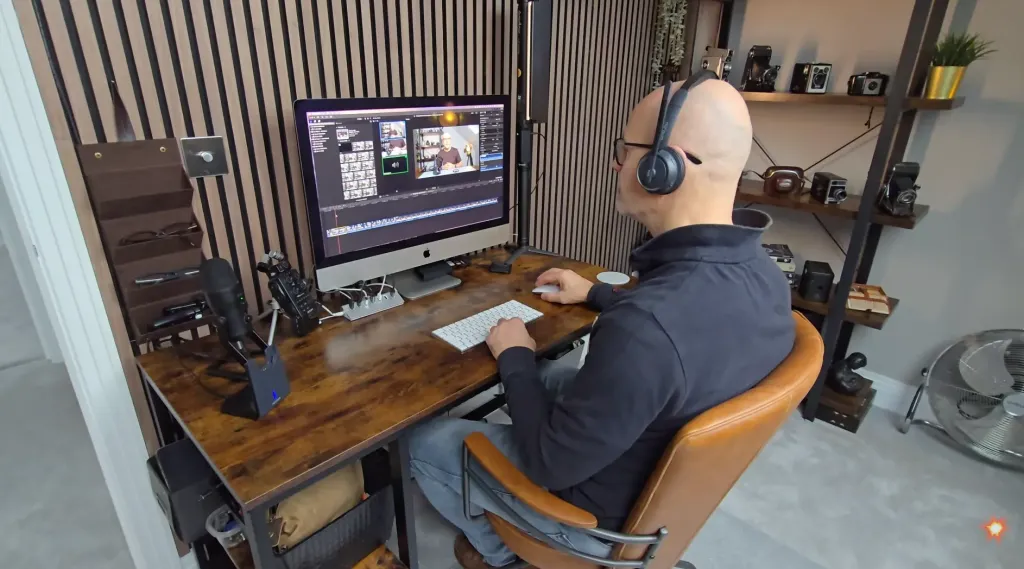 Tim using the Nuroum HP31D wireless headset with mic while editing video at his desk, highlighting its immersive over-ear design for focused work and media production