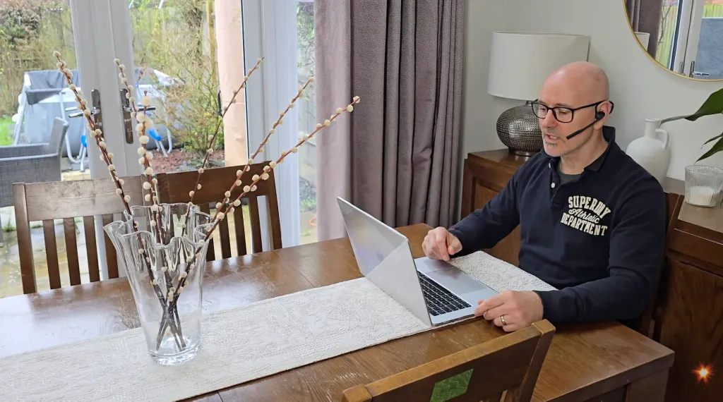 Tim using the Nuroum OpenEar Pro 2 wireless headset with mic at home during a work call, demonstrating its lightweight open-ear design for remote work use