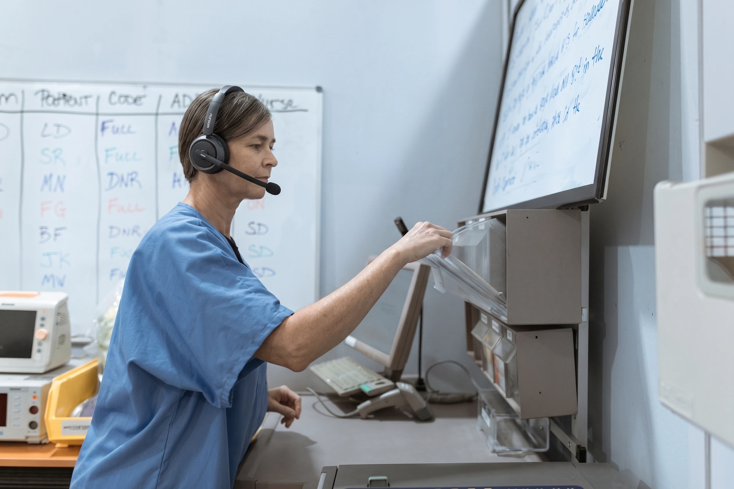 Medical triage reception desk with staff wearing single ear wireless headset