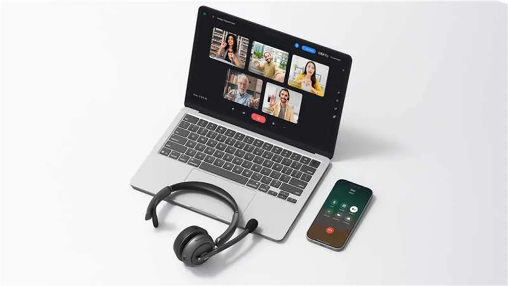 A laptop displaying a multi-person video conference next to a smartphone and a professional wireless headset, showcasing efficient tools for online teaching.