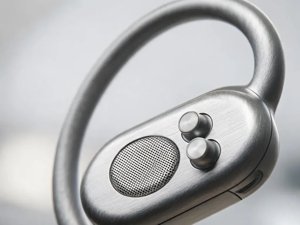 Macro detail shot of the Nuroum OpenEar Pro 2 headset showing the lightweight hook, dual-mic assembly, and sleit open-ear structure