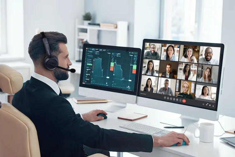 Call center agent wearing dual ear headset smiling at desk