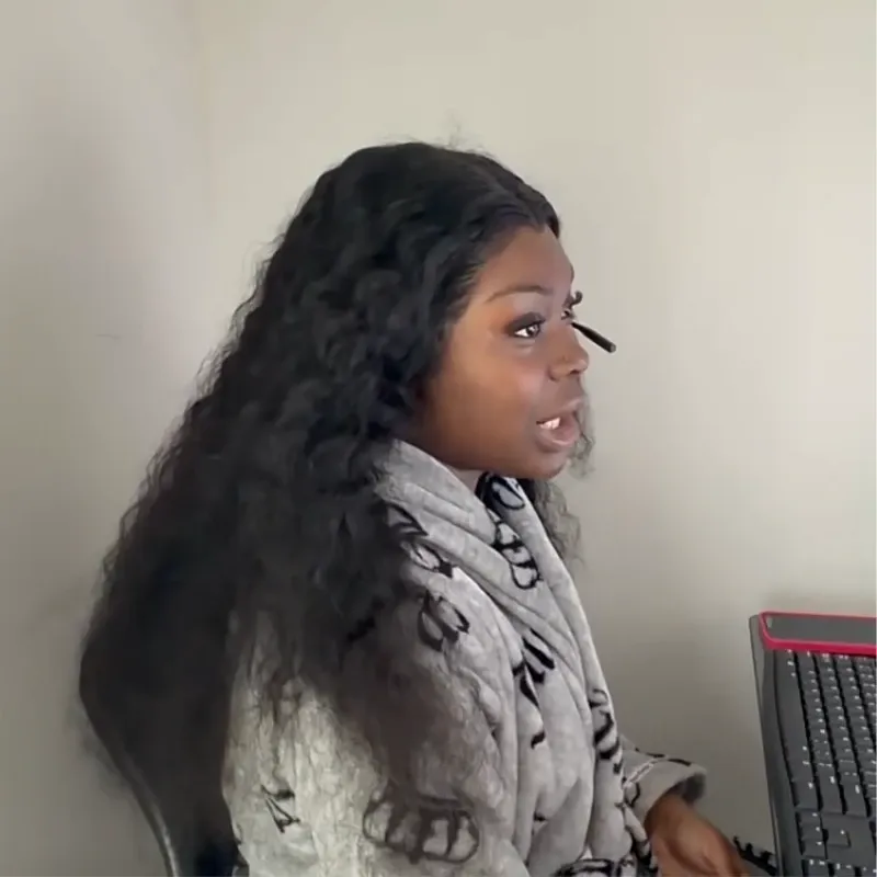 Side view of a woman wearing an open-ear headset with an adjustable boom microphone while speaking at her computer.