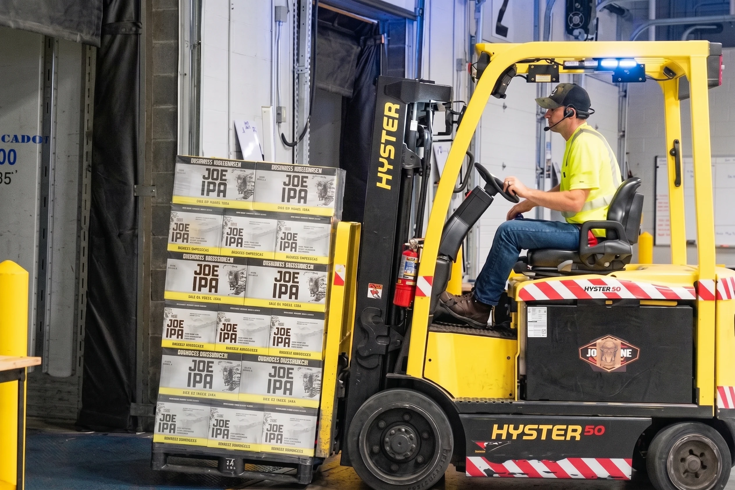 Logistics coordinator in warehouse wearing safety glasses and headset